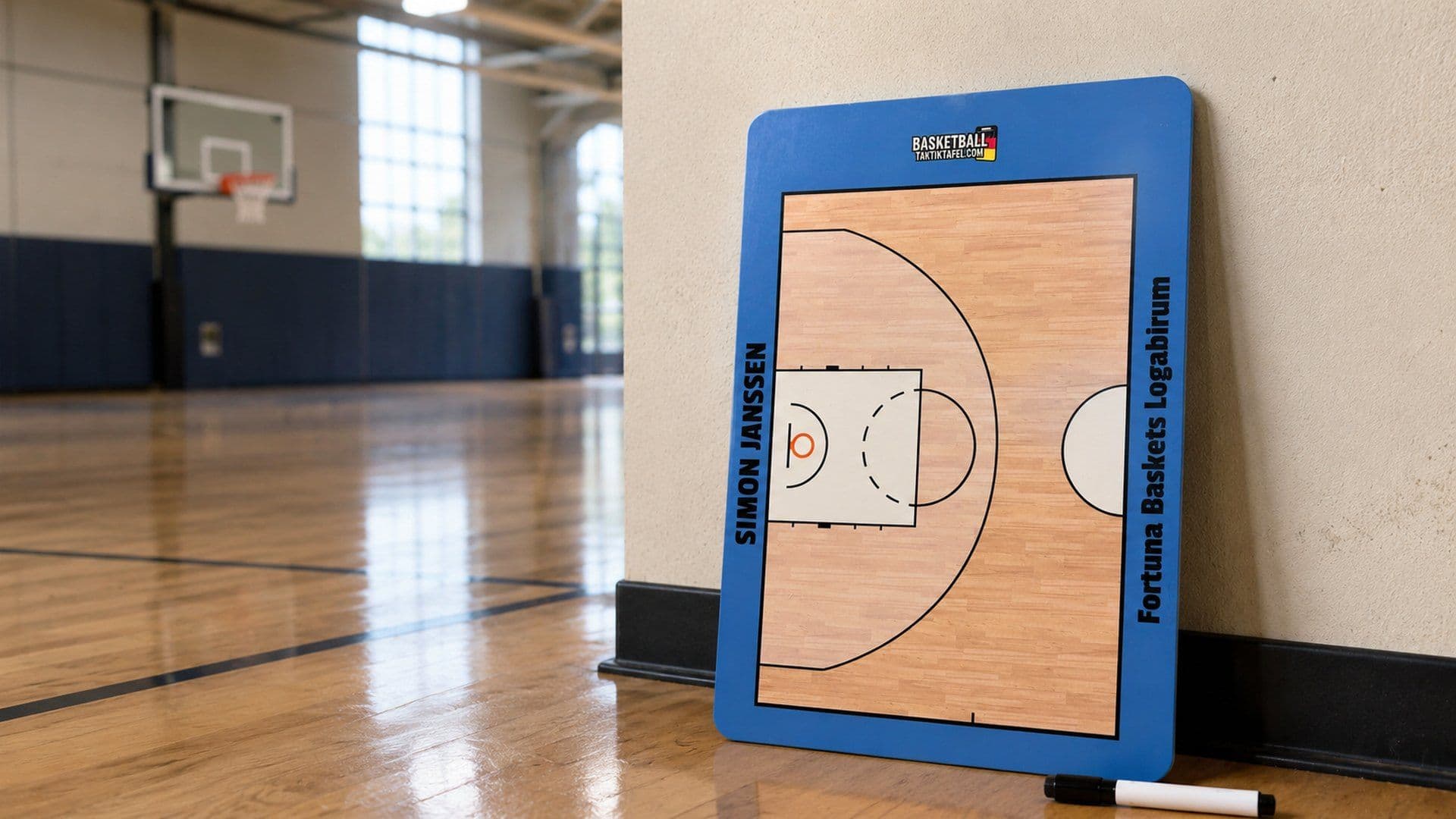 Personalised coaching board leaning against a sports hall wall, with the printed court and a marker pen beside it
